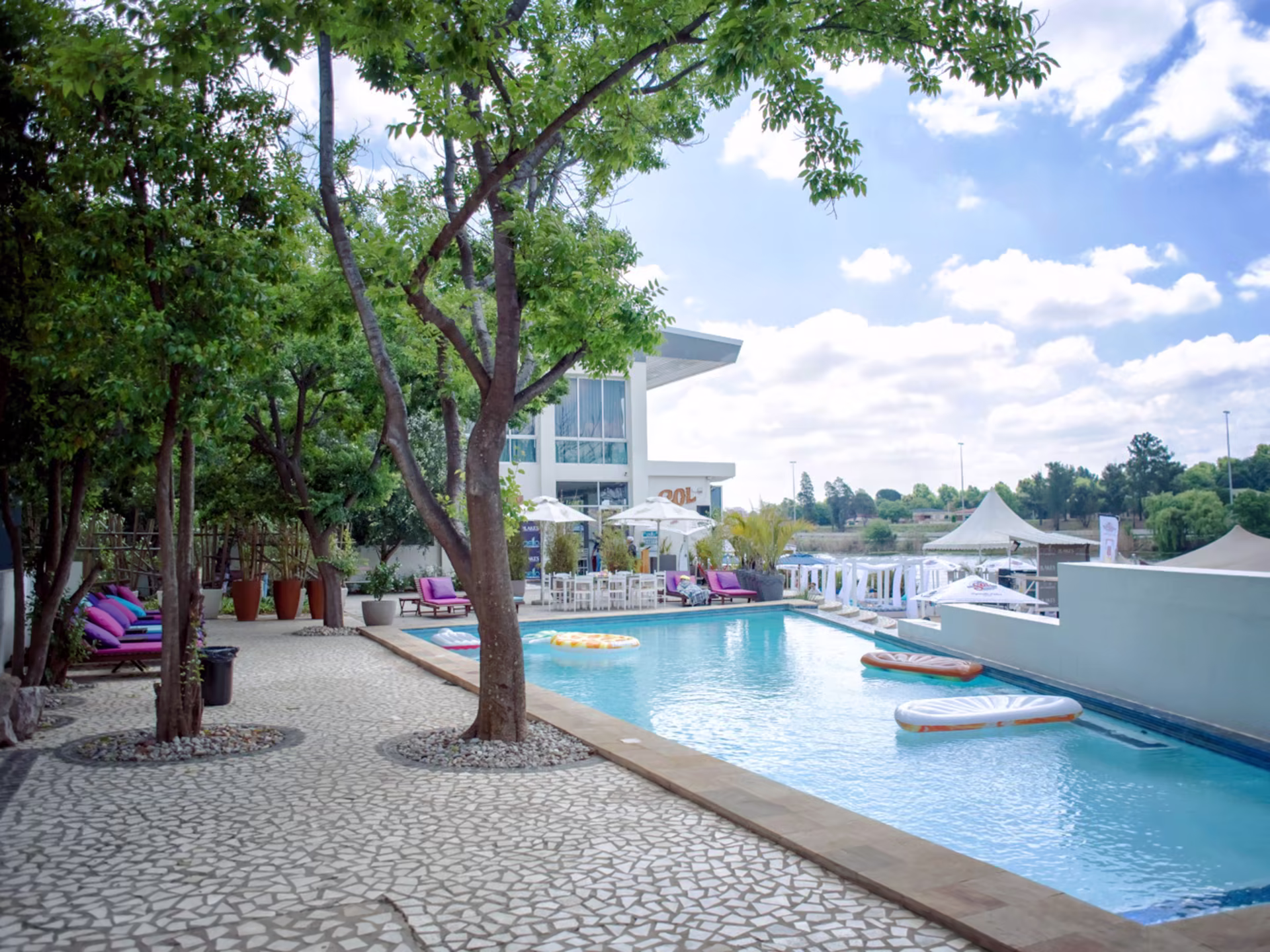 Pool and lakeside loungers under shady trees